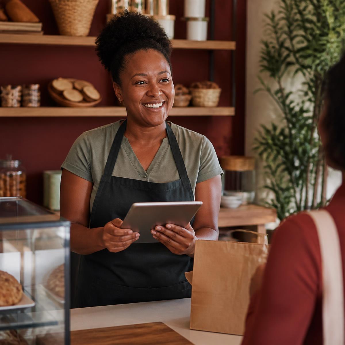Commerçante en Guadeloupe utilisant sa tablette pour préparer une commande à livrer